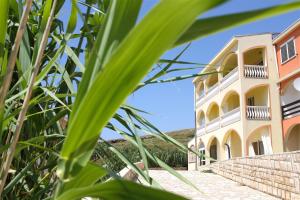 a view of a building from behind some plants at Villa Luka in Pag