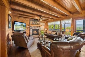 a living room with leather furniture and a fireplace at Mountain Paradise by Eden Crest in Sevierville