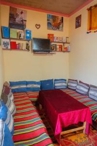 スコーラにあるカスバ ラ ダッ ドールのベッド2台、壁掛けテレビが備わる客室です。