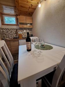 a bottle of wine sitting on a table with two wine glasses at Mountain Life in Žabljak +9 photos