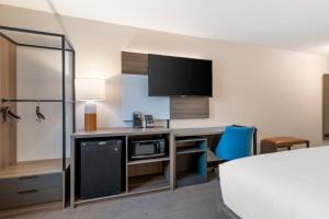 a hotel room with a desk with a microwave at Comfort Inn & Suites Saratoga Springs in Saratoga Springs