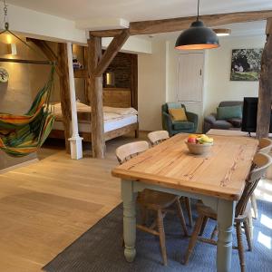 un salon avec une table en bois et une chambre dans l'établissement Apartment Am Fluss im Haus An der Rur, à Monschau
