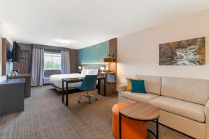 pokój hotelowy z łóżkiem i kanapą w obiekcie Comfort Inn & Suites Saratoga Springs w mieście Saratoga Springs