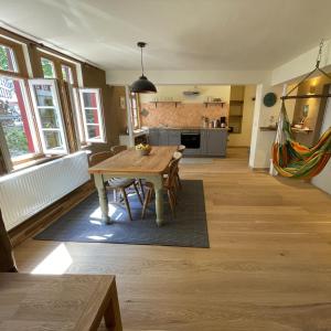 une cuisine et une salle à manger avec une table en bois dans l'établissement Apartment Am Fluss im Haus An der Rur, à Monschau