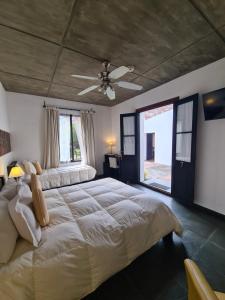 a bedroom with a large bed with a ceiling fan at Posada El Capullo in Colonia del Sacramento +78 photos