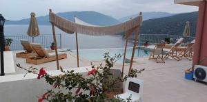 a patio with chairs and a view of the water at Augustela Villa SeaView Vacation Villa in Ayia Evfimia