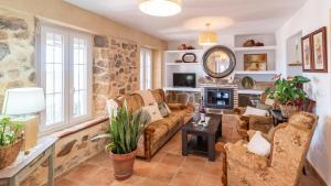 a living room with a stone wall at Rubito el Olmo Villanueva de la Concepción by Ruralidays in Villanueva de la Concepción