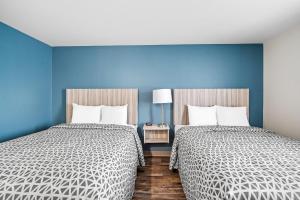 Säng eller sängar i ett rum på WoodSpring Suites Winston-Salem near Hanes Mall