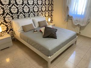 Una cama con dos almohadas encima en un dormitorio. en Golden House Holiday, en Belpasso