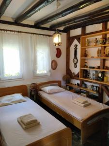 two beds in a room with two windows at Σπίτι στο κυμα in Litochoro