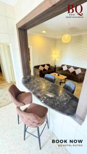 البندقية للخدمات الفندقية BQ HOTEL SUITES في بريدة: غرفة معيشة مع طاولة وكراسي من الرخام