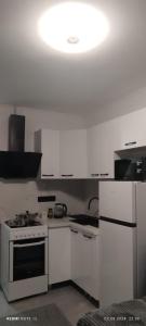 a kitchen with white cabinets and a stove and a light at Квартира- студия in Chişinău +6 photos