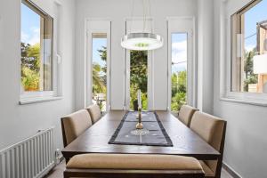 a dining room with a table and chairs and windows at Villa Blue Dreams in Maleme in Ayiá