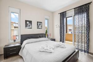 a bedroom with a large bed and two windows at Villa Blue Dreams in Maleme in Ayiá