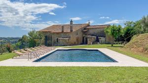 a pool in front of a house with chairs at Majordoms - Mas Maria Carmen Dalmau in Sant Andreu del Terri