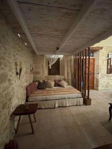 1 dormitorio con 1 cama grande en una pared de piedra en Village Little House at Roustika en Roústika