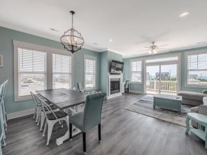 een eetkamer en woonkamer met een tafel en stoelen bij Strand Bungalow in Surf City