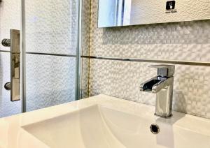 a bathroom sink with a faucet and a mirror at Casa Varela en Noia in Noya