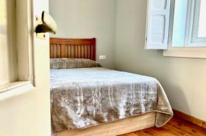 a bedroom with a bed with a blanket on it at Casa Varela en Noia in Noya