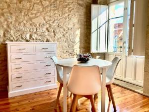 a dining room with a white table and chairs at Casa Varela en Noia in Noya