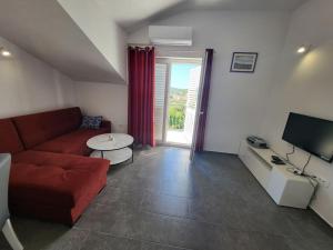 a living room with a red couch and a television at Apartman Ane in Slano