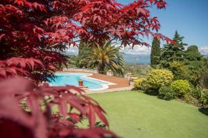 una piscina en un jardín con hojas rojas en Primavera Villa Sea view, en Selianitika