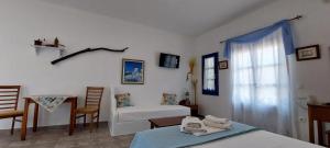 a room with two beds and a chair and a window at Aegean Star Hotel in Karavostasi