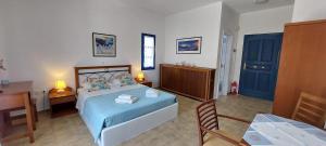 a bedroom with a bed and a table and a desk at Aegean Star Hotel in Karavostasi