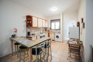 a kitchen with a table and chairs and a refrigerator at Dasillion Apartment by Alexia in Igoumenitsa +12 photos
