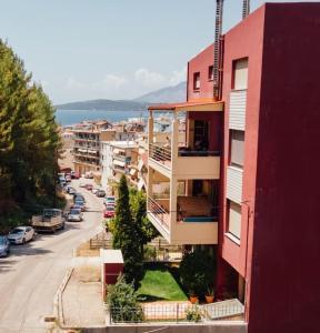 a red building on a city street with cars parked at Dasillion Apartment by Alexia in Igoumenitsa