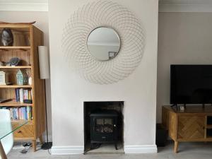 einen Spiegel über einem Kamin im Wohnzimmer in der Unterkunft Park View Cottage - 3 Beds - 2 Bedrooms in Sewerby in Sewerby