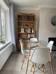 ein Esszimmer mit einem Glastisch und weißen Stühlen in der Unterkunft Park View Cottage - 3 Beds - 2 Bedrooms in Sewerby in Sewerby