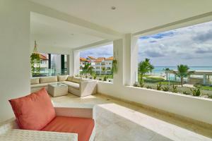 a living room with a couch and two large windows at Beautiful Modern Condo At Cap Cana, Punta Cana in Punta Cana