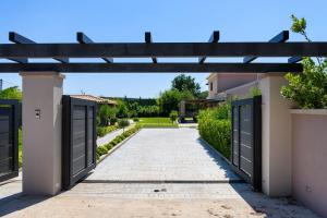 an entrance to a house with two gates and a driveway at Villa Black White Dassia in Dassia