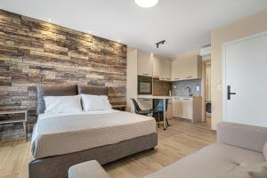 een slaapkamer met een bed en een bakstenen muur bij Grande Mare with Sea view in Amoudara Herakliou