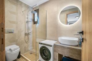 een badkamer met wastafel en wasmachine bij Grande Mare with Sea view in Amoudara Herakliou +4 foto's