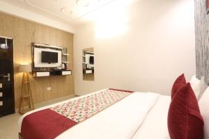 a bedroom with a bed and a tv on the wall at Hotel Grand Kiara Delhi Airport By SS Group in New Delhi