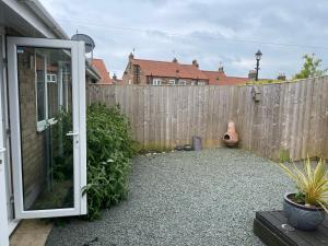 ein Hinterhof mit einem Holzzaun und einer Bank in der Unterkunft Park View Cottage - 3 Beds - 2 Bedrooms in Sewerby in Sewerby