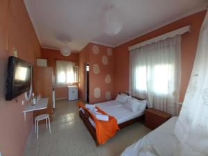 a hotel room with a bed and a television at Basilio's Studios in Leptokaria