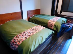 two beds sitting next to each other in a room at Yamakikan in Naganohara