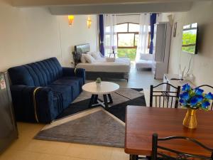 a living room with a blue couch and a table at Julia Ocean View Villa in Ukunda