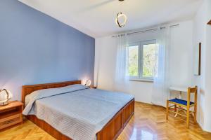 a bedroom with a bed and a desk and a window at Apartman Meri in Cres +16 photos