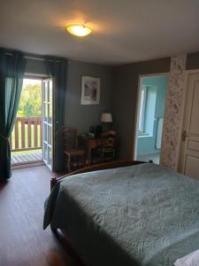 a bedroom with a large bed and a balcony at les accacias in Moyenmoutier