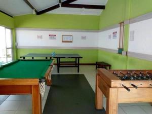 a room with two ping pong tables and green walls at Apartamento Cantinho na Praia in Ilhéus