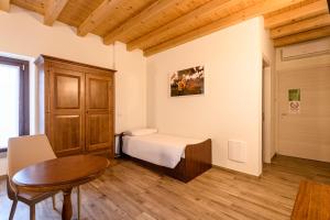 een kleine slaapkamer met een bed en een tafel bij il Glicine B&B RISTORANTE in Cazzago San Martino
