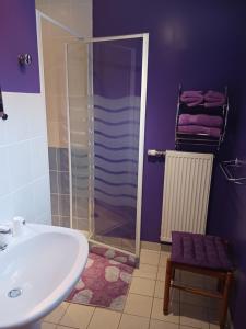 a bathroom with a sink and a shower with purple walls at les accacias in Moyenmoutier +14 photos