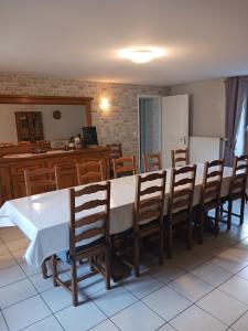 a dining room with a white table and wooden chairs at les accacias in Moyenmoutier