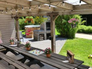 une table de pique-nique sous une pergola en bois dans une cour arrière dans l'établissement Coeur de Loup, à Sourbrodt