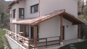a house with a wooden roof and a porch at La Senda del Casaño in Canales +1 photo
