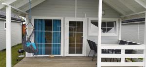 a porch of a house with glass doors and a deck at Domki Martes Wicie in Wicie